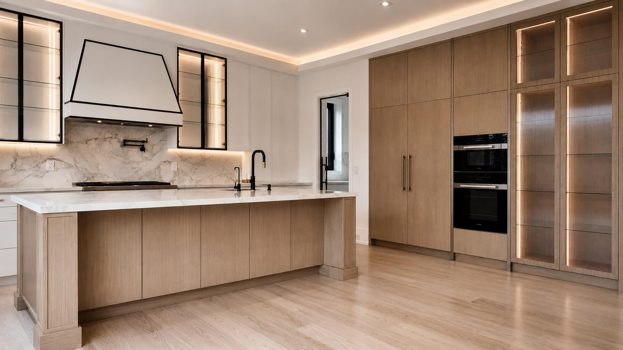 Warm contemporary kitchen with wood cabinetry and marble surfaces