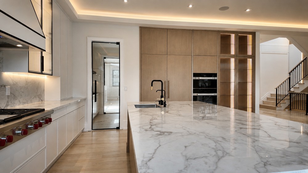 Marble island overlooking wood tall cabinetry