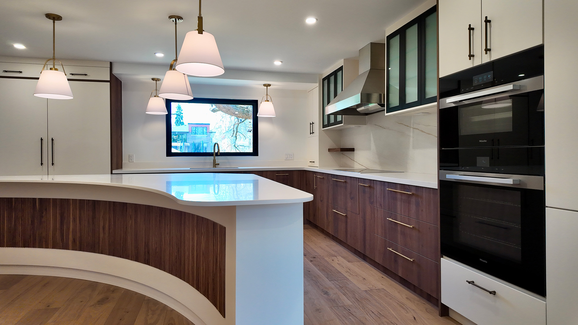 Contemporary kitchen with a curved fluted-walnut island and pendant lighting
