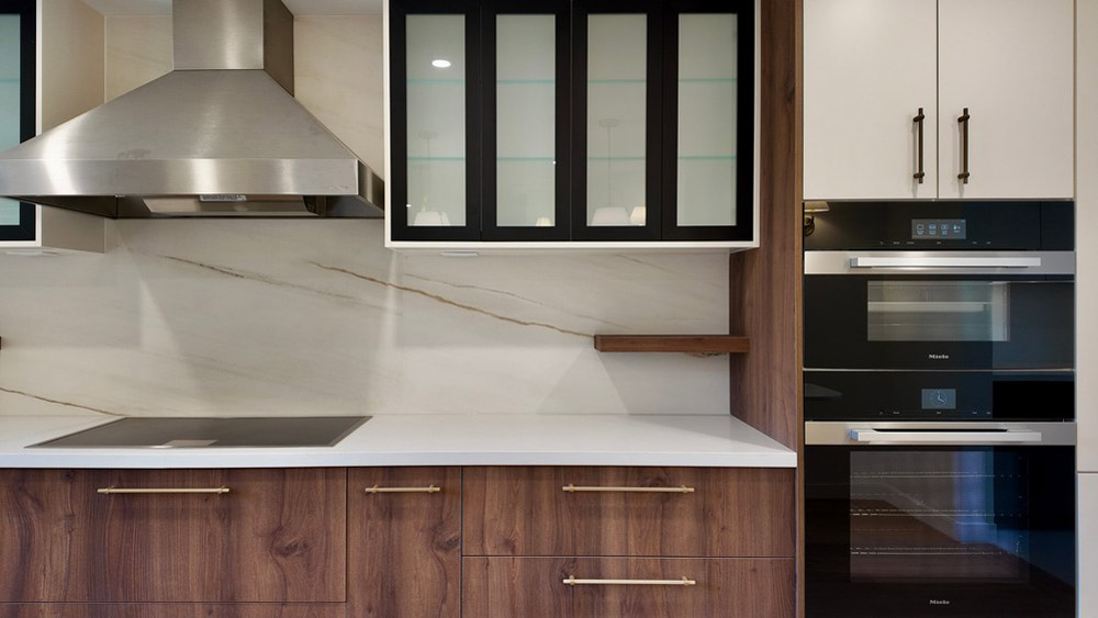 Walnut cabinetry run with induction cooktop and stainless chimney hood