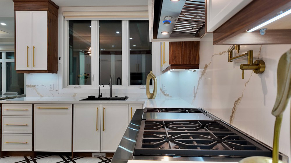 Rangetop and prep run with brass pot filler and marble backsplash