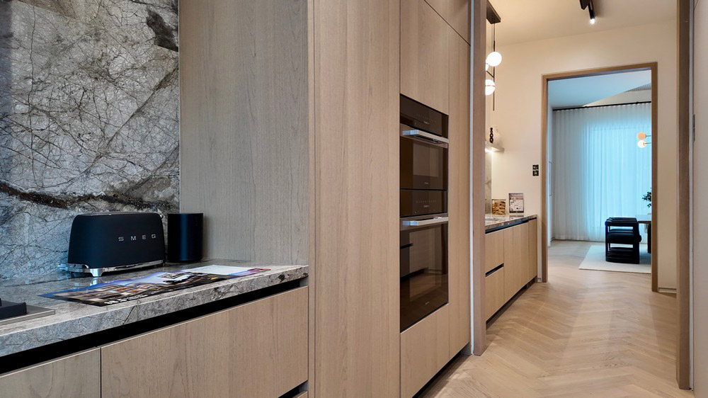 Miele built-in ovens set into warm wood tall cabinetry