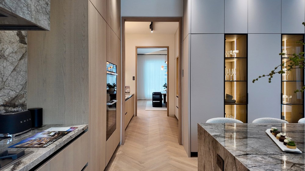 View through the kitchen with stone backsplash and lit display cabinetry