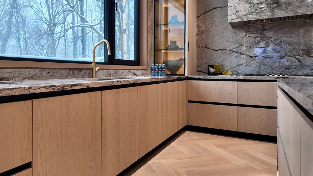 Stone countertop run with brass tapware and illuminated display cabinet