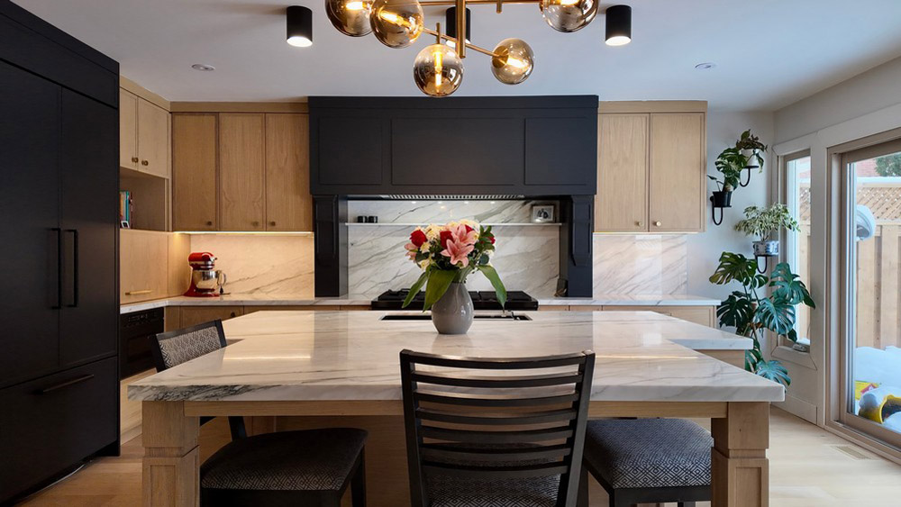 Island seating facing the custom hood surround and stone backsplash