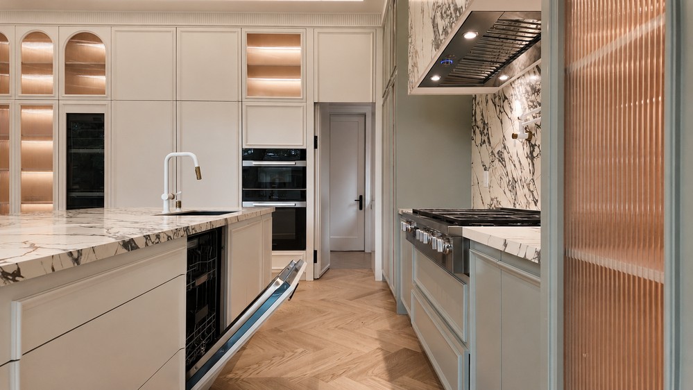 Island prep sink and Miele PureLine ovens set into the white cabinetry