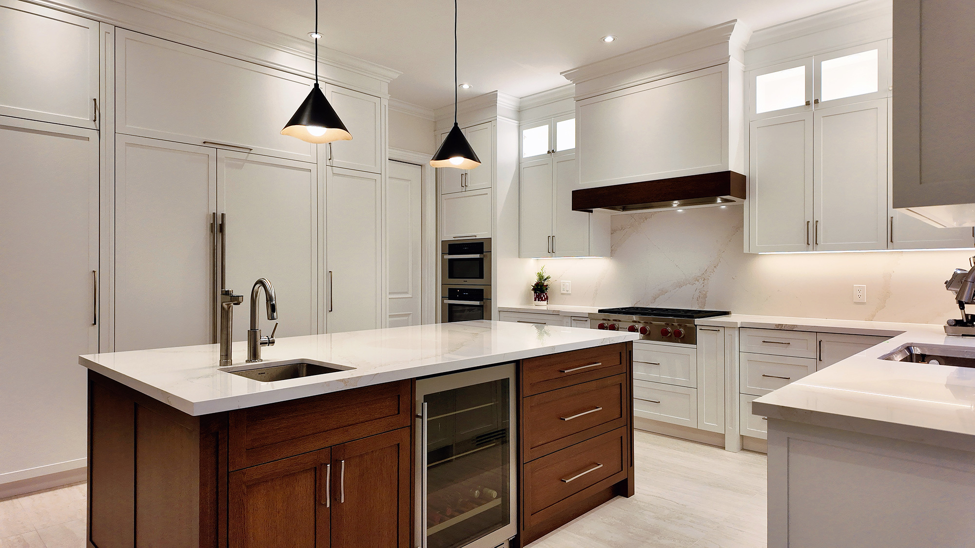 Timeless white kitchen with dark wood island and black pendant lighting