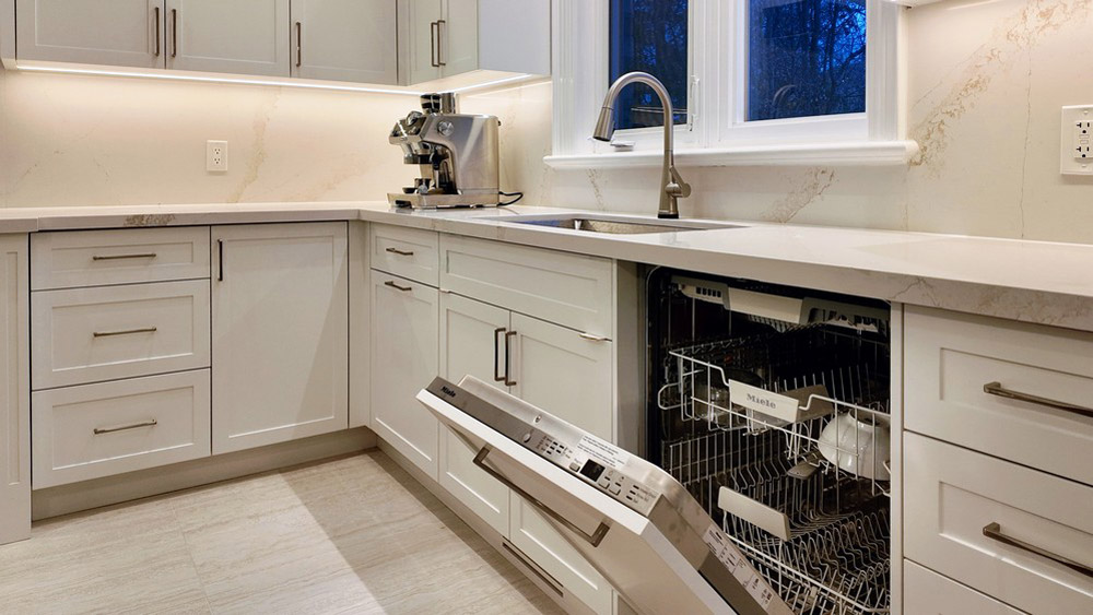Miele panel-ready dishwasher open beside the window sink run