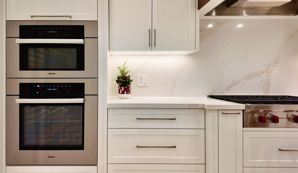 Miele speed oven and wall oven stacked in the white tall cabinetry