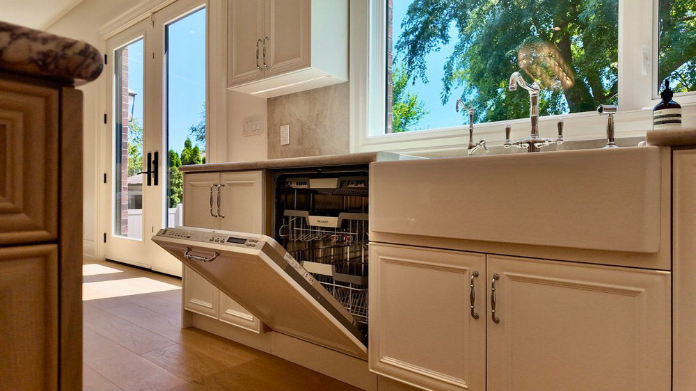 Miele fully integrated dishwasher open beside the farmhouse sink