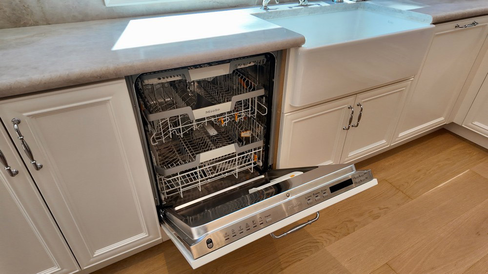 Miele integrated dishwasher shown open with the panel front