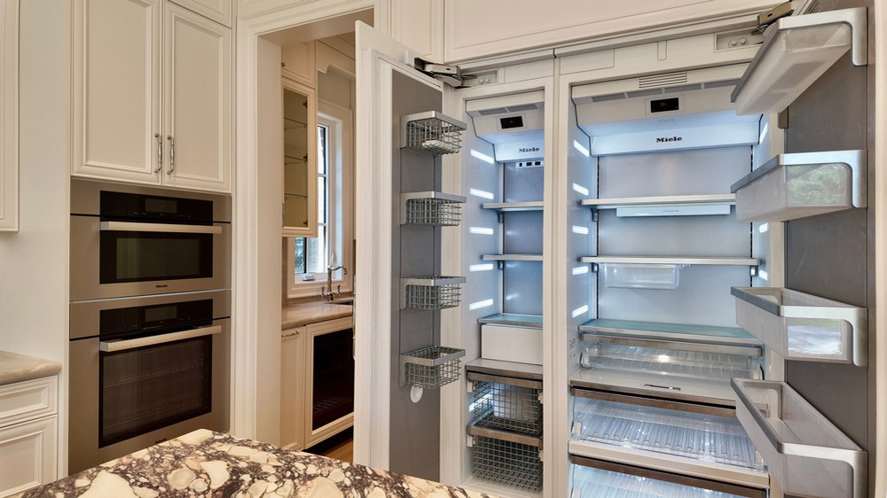 Miele refrigeration open alongside the stacked Miele ovens